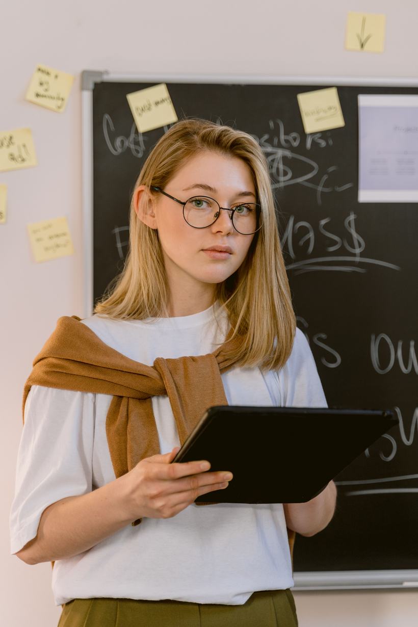 Educator holding a tablet in a classroom